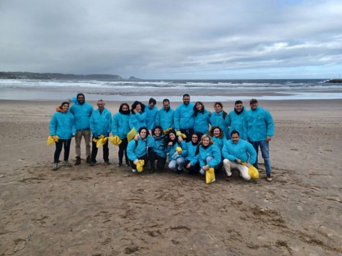 Enagás professionals during an environmental volunteering activity on the beach in Gijón